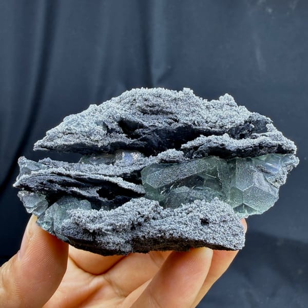 Green fluorite in hollows of a layered quartz-coated matrix from Fujian — complete view