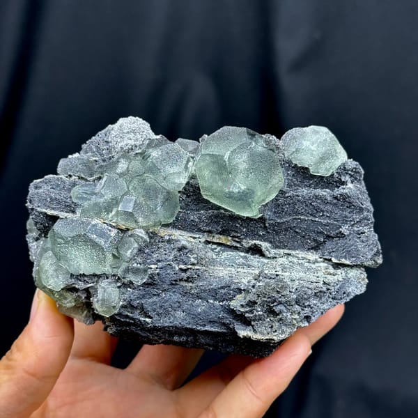 Rounded pale green fluorite on dark quartz-coated matrix from Fujian — complete view