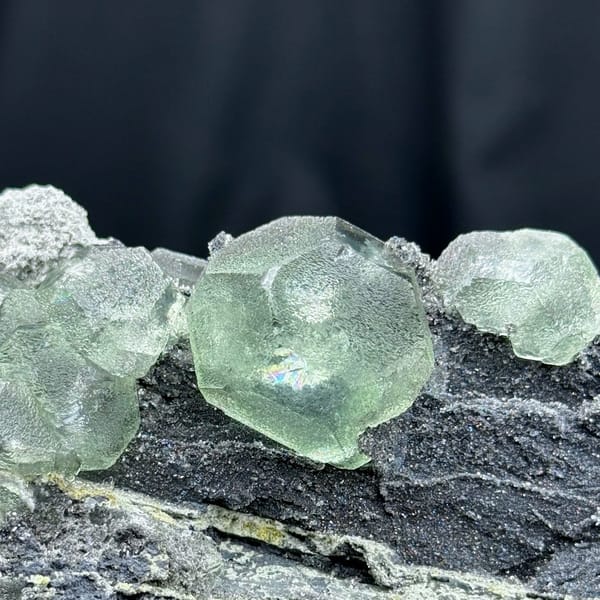 Rounded pale green fluorite on dark quartz-coated matrix from Fujian — alternate view