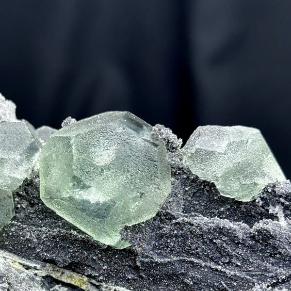 Rounded pale green fluorite on dark quartz-coated matrix from Fujian — alternate view
