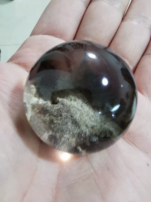 Complete reverse palm-held view of the exact ghost quartz sphere and its sloping base inclusion