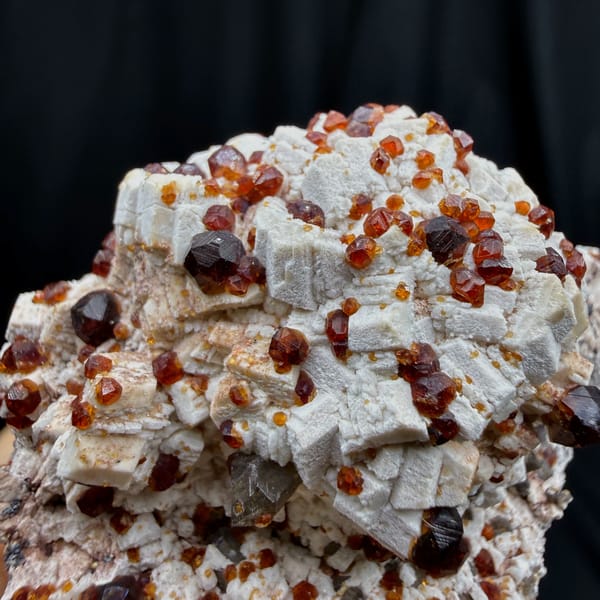 Glossy red-brown garnet crystals on white feldspar from Fujian — alternate view
