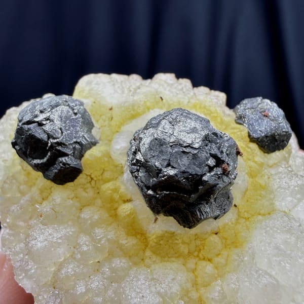 Dark spherical pyrite balls on yellow quartz from Jiangxi — detail view