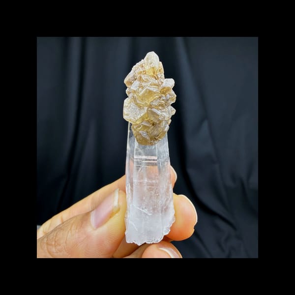 Complete front view of elongated colorless quartz with calcite