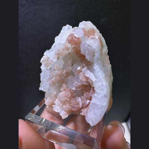Peach-pink rhodochrosite in a white quartz geode pocket — complete view