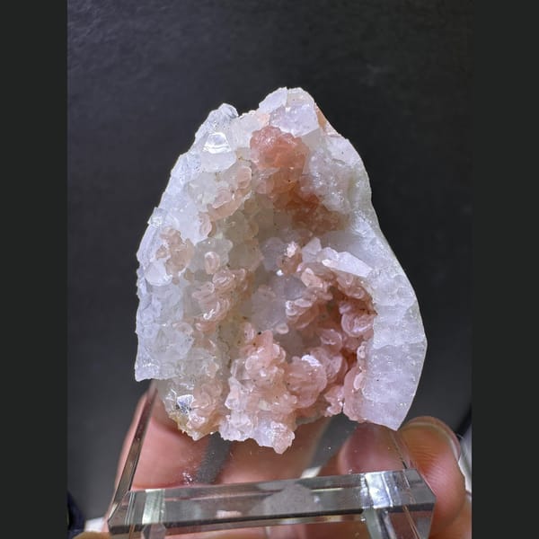 Peach-pink rhodochrosite in a white quartz geode pocket — alternate view