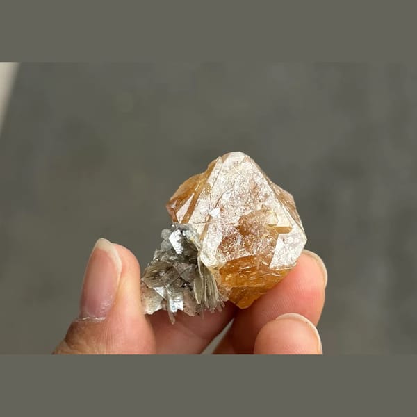 Orange scheelite octahedron with silvery mica from Xuebaoding — complete view
