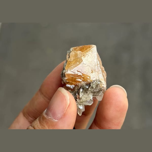 Orange scheelite octahedron with silvery mica from Xuebaoding — alternate view