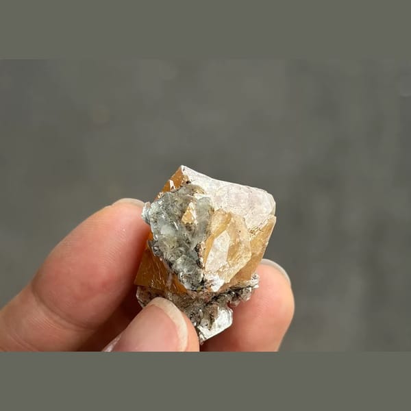 Orange scheelite octahedron with silvery mica from Xuebaoding — alternate view