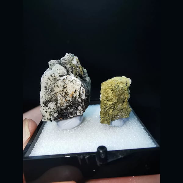 Two feldspar specimens with black tourmaline and epidote — complete view