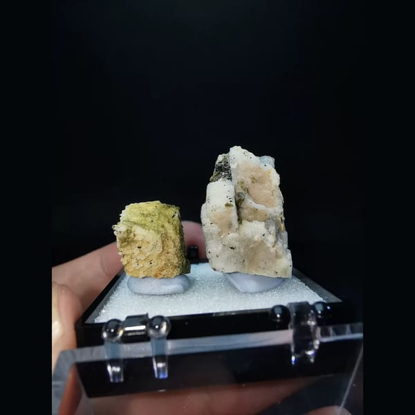 Two feldspar specimens with black tourmaline and epidote — alternate view