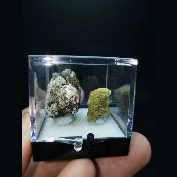 Two feldspar specimens with black tourmaline and epidote — detail view