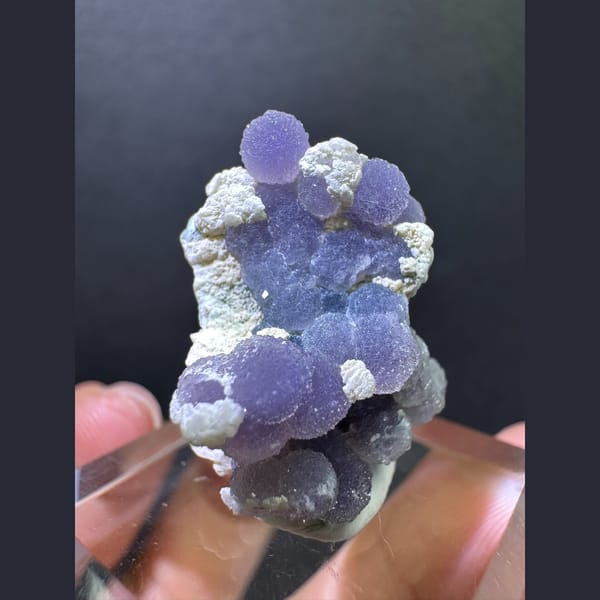 Purple grape agate spheres on matrix — complete view