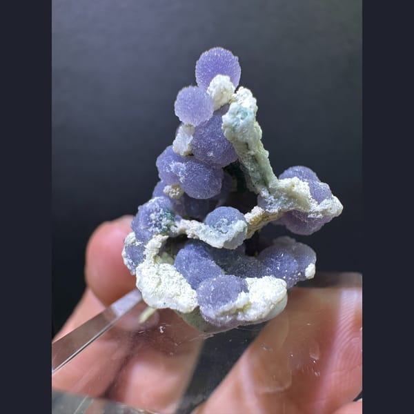 Purple grape agate spheres on matrix — detail view