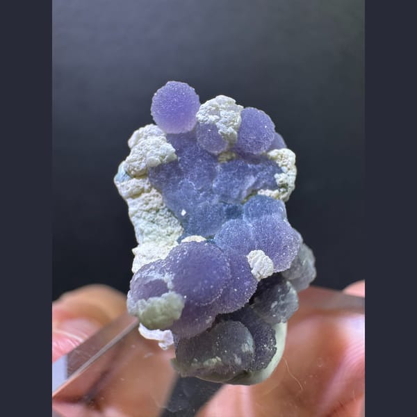 Purple grape agate spheres on matrix — detail view