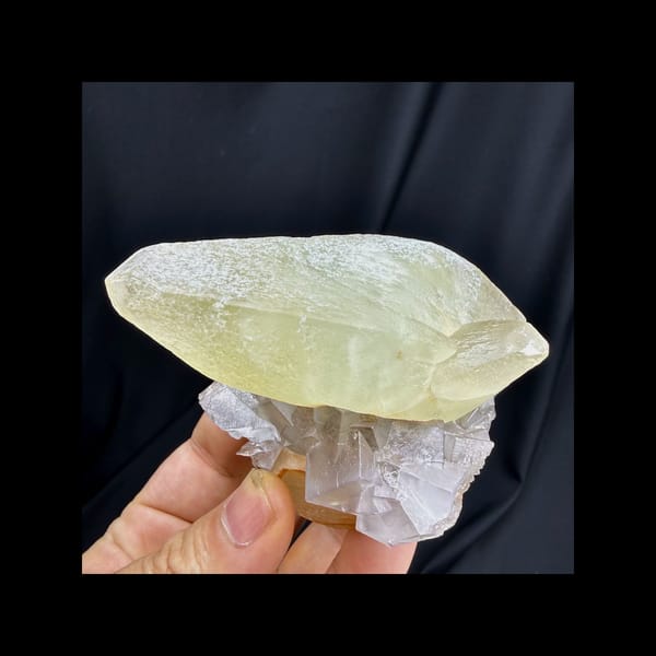 Complete front view of green calcite with purple fluorite