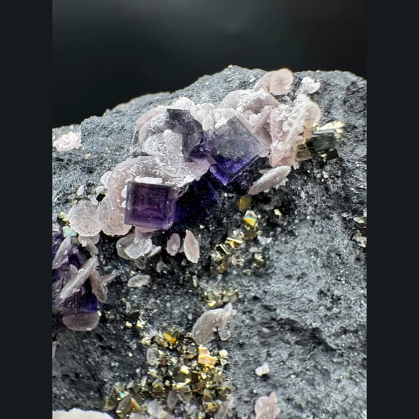 Purple-blue cubic fluorite with pyrite and rhodochrosite — detail view