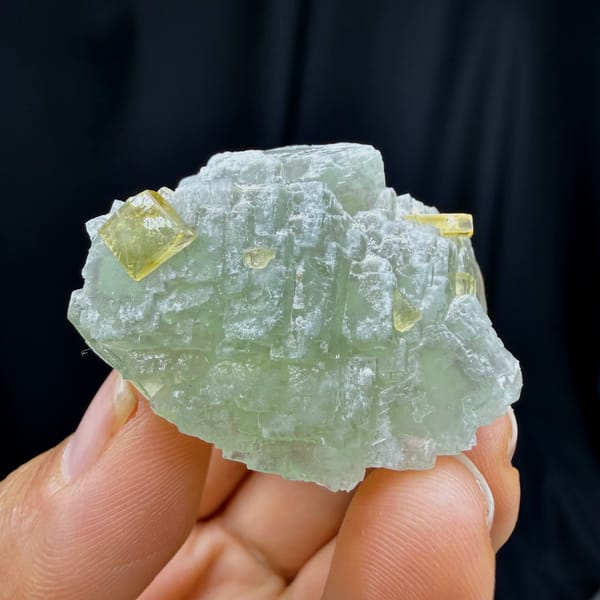 Complete front view of pale green stepped fluorite with yellow barite crystals