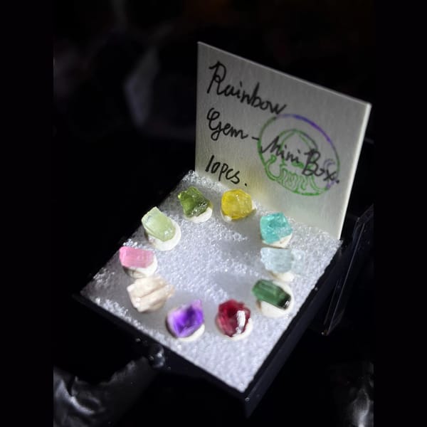 Ring of ten rainbow gem rough crystals in a mini display box — alternate view