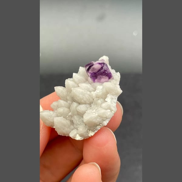 Deep purple fluorite crystal among white quartz balls from Inner Mongolia — complete view