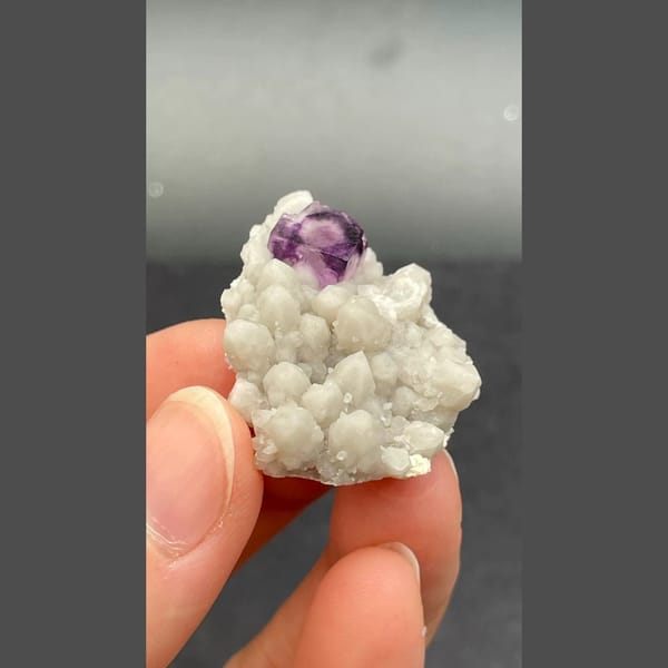 Deep purple fluorite crystal among white quartz balls from Inner Mongolia — alternate view