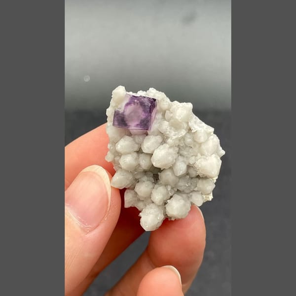 Deep purple fluorite crystal among white quartz balls from Inner Mongolia — detail view