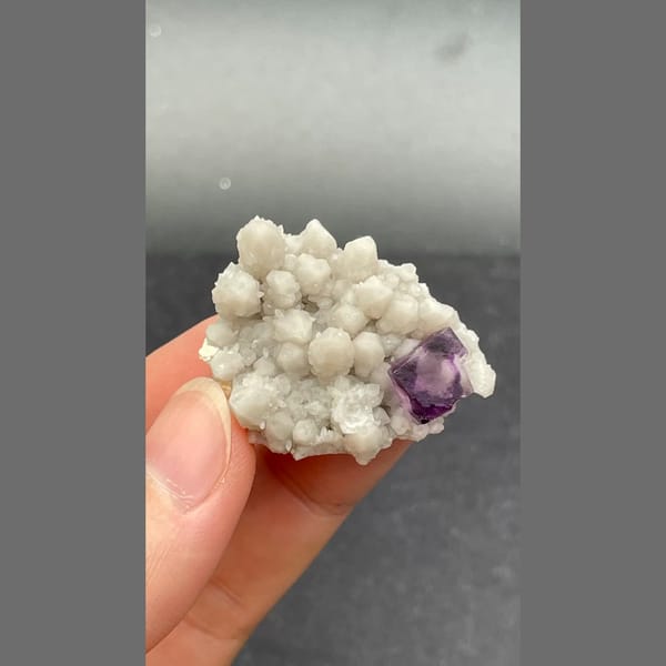Deep purple fluorite crystal among white quartz balls from Inner Mongolia — detail view