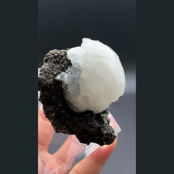 White stilbite ball on dark basalt from Aurangabad, India — detail view