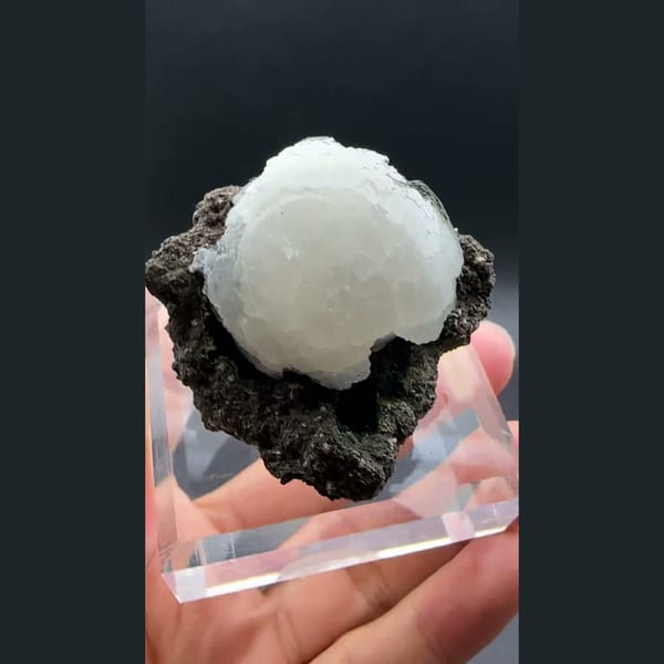 White stilbite ball on dark basalt from Aurangabad, India — detail view