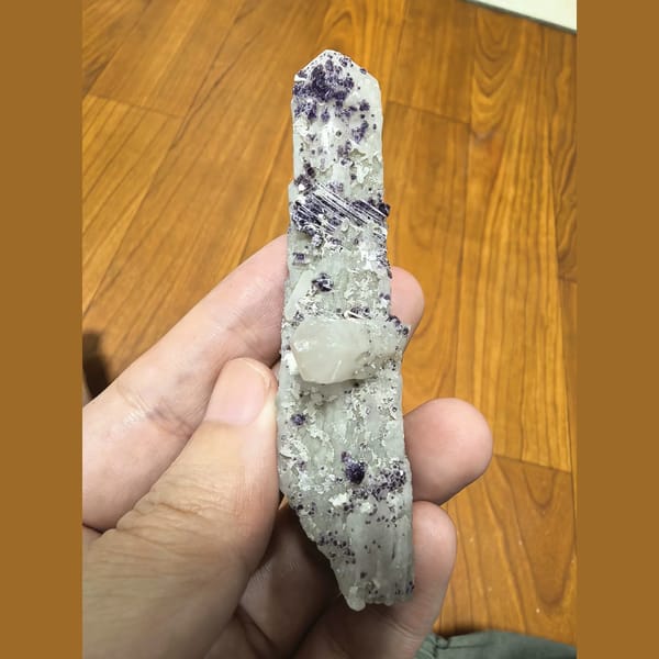 Purple beaded fluorite on slender white quartz crystal — complete view