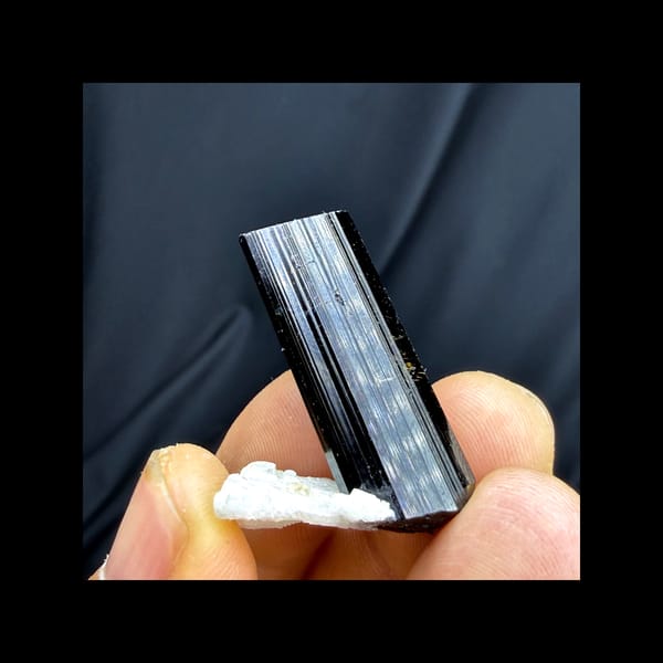 Complete side view of black tourmaline on pale feldspar