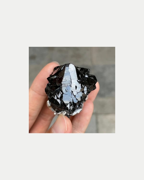 Complete front view of lustrous cassiterite with mica