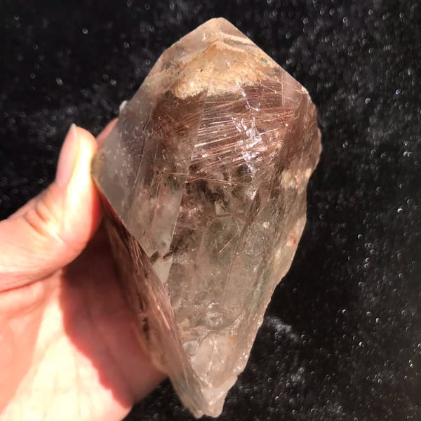 Quartz crystal densely packed with red-copper rutile needles — detail view