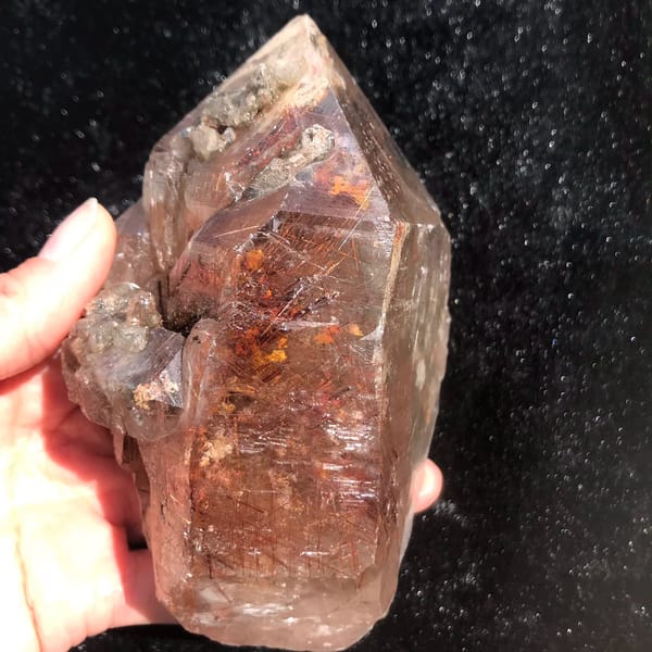 Quartz crystal densely packed with red-copper rutile needles — detail view