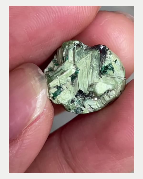 Complete left oblique view of green mushistonite over kesterite