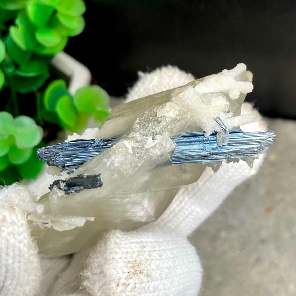 Glassy calcite crystal with dark metallic stibnite blades — alternate view