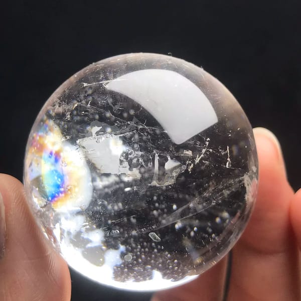 Small clear quartz sphere with dark tourmaline inclusions from Brazil — detail view