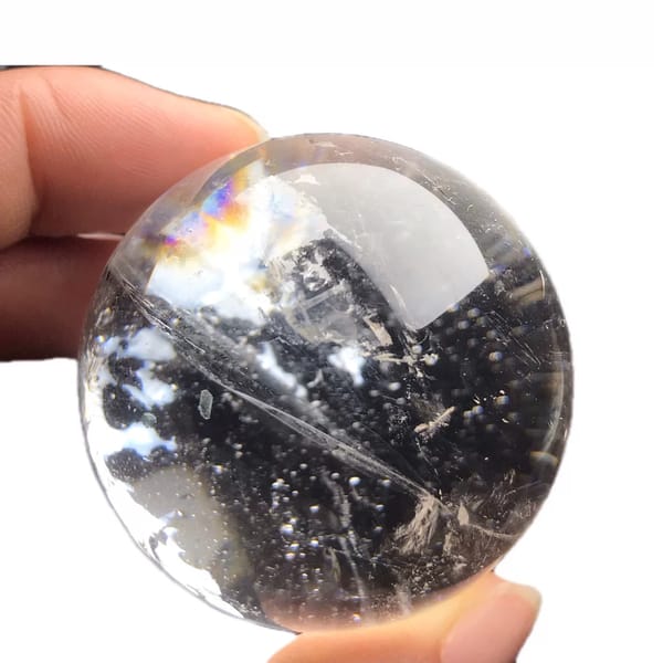 Small clear quartz sphere with dark tourmaline inclusions from Brazil — detail view