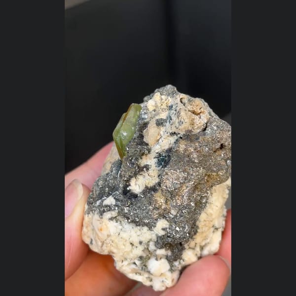 Green titanite twin crystal with mica and feldspar from Pakistan — complete view