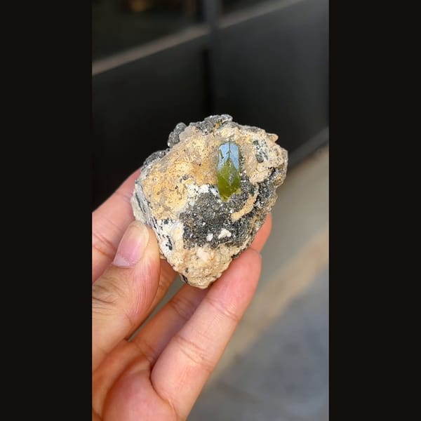 Green titanite twin crystal with mica and feldspar from Pakistan — alternate view
