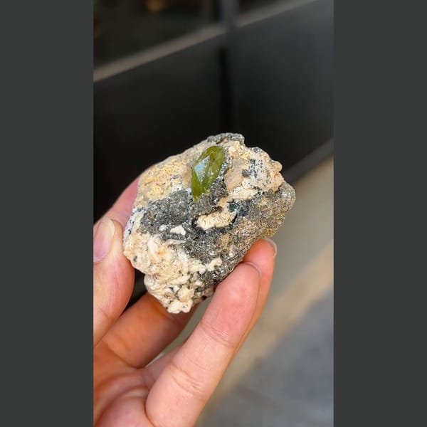 Green titanite twin crystal with mica and feldspar from Pakistan — alternate view