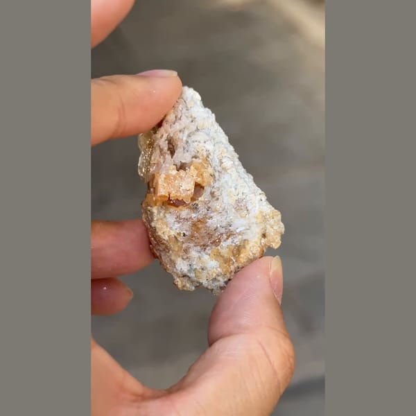 Flattened pale beryl with orange scheelite from Xuebaoding, Sichuan — detail view