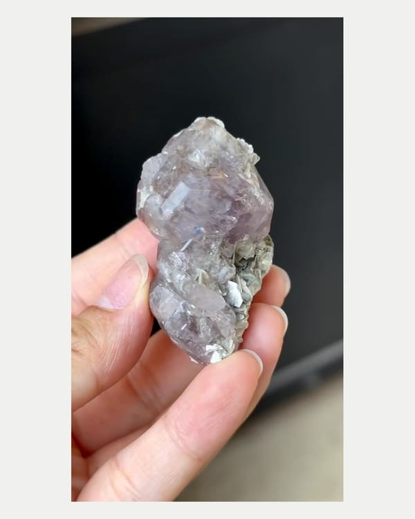 Complete right oblique view of large purple apatite with mica