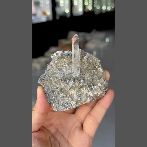 Slender clear quartz crystal on silvery mica from Xuebaoding, Sichuan — complete view