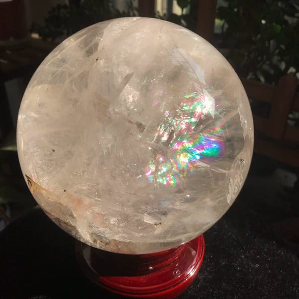 Clear quartz sphere with a thick golden included rod from Brazil — detail view
