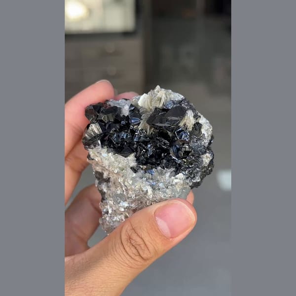Glossy black cassiterite crystals with mica from Xuebaoding, Sichuan — detail view