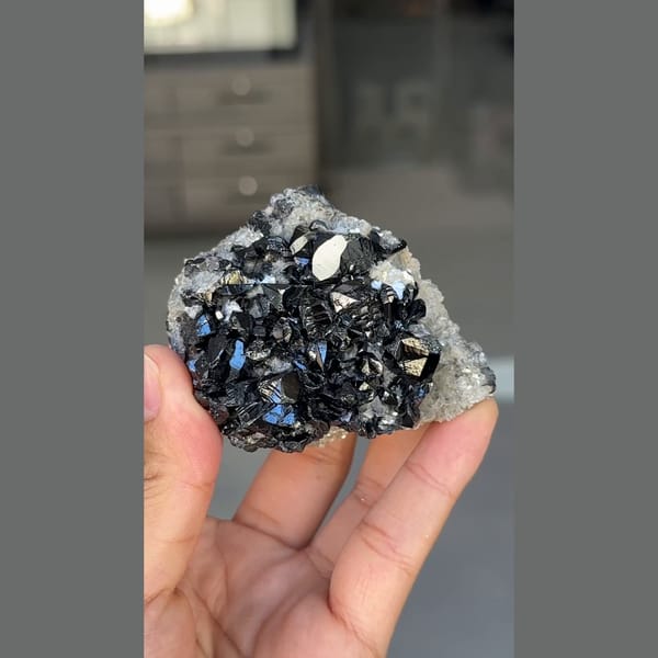Glossy black cassiterite crystals with mica from Xuebaoding, Sichuan — detail view