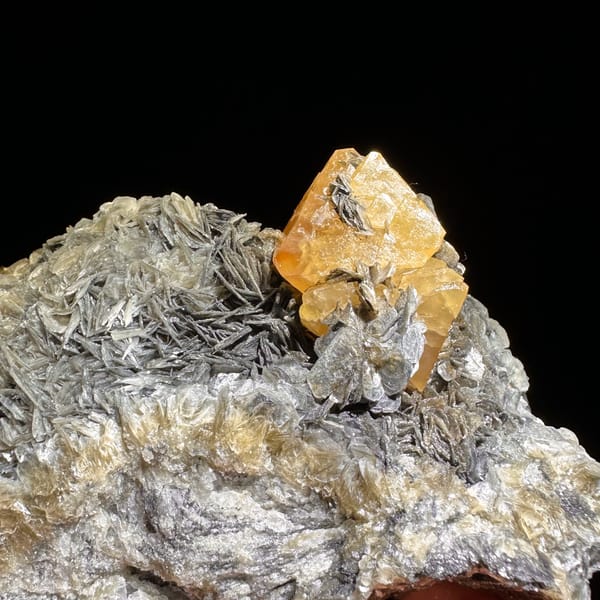 Orange scheelite crystal on silvery mica matrix from Xuebaoding — alternate view