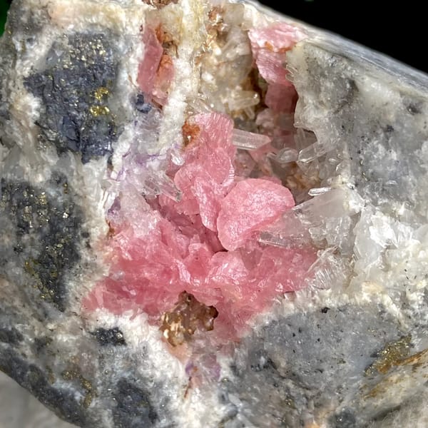 Bright pink rhodochrosite crystals with quartz on grey matrix — alternate view