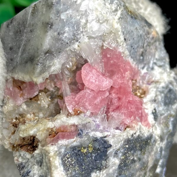 Bright pink rhodochrosite crystals with quartz on grey matrix — detail view